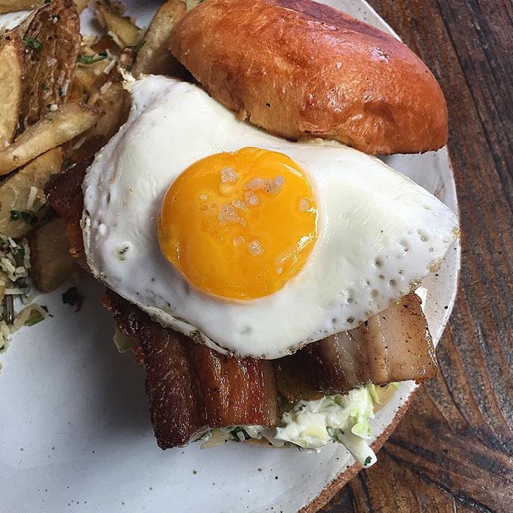 Might as well pig out for the remainder of the year @carnivorr is enjoying a Pork Belly, Fried Egg, Jalapeño Relish slaw and Fried Green Tomato sandwich. @restaurationlb made things better by making it an ALL DAY BREAKFAST SANDWICH!!! visit them and let us know what you think!! #YGET #YouGottaEatThis #WDYET