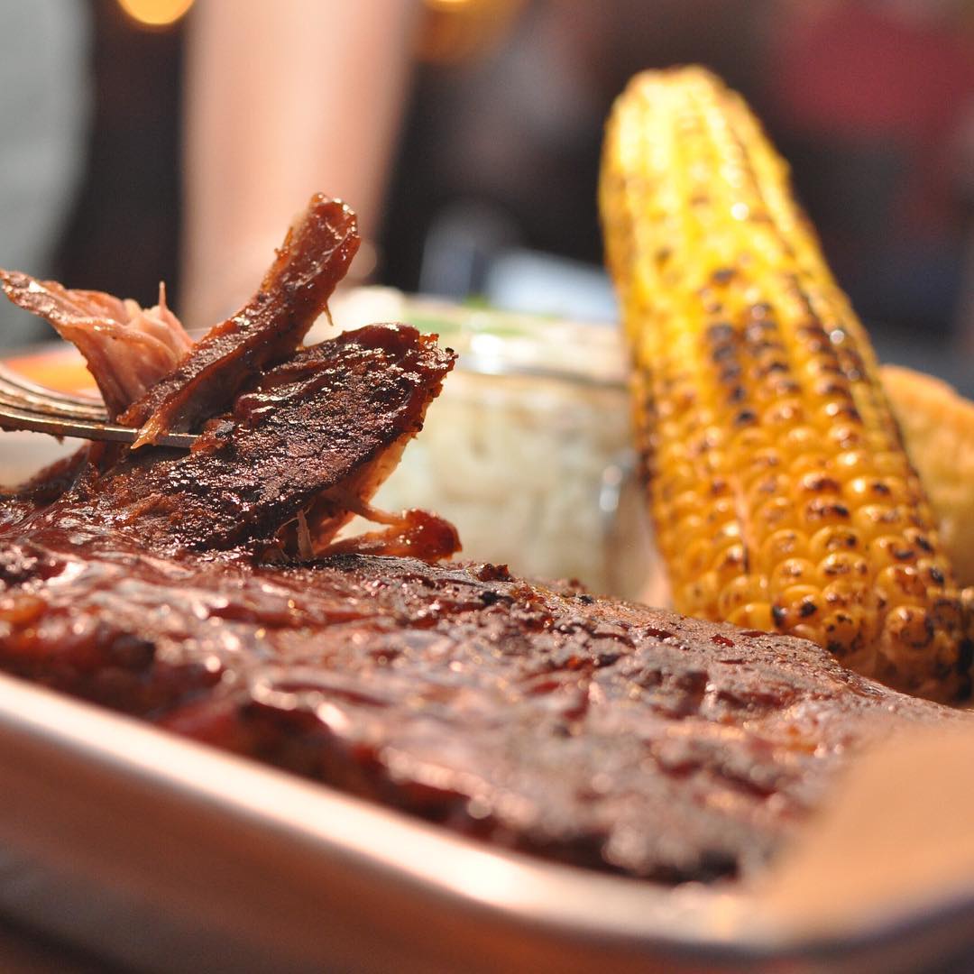 It’s DINNER TIME! 🍽 Half rack of tender fall off the bone Carolina BBQ ribs served with grilled corn ,Whiskey butter, macaroni salad and fall apart corn bread