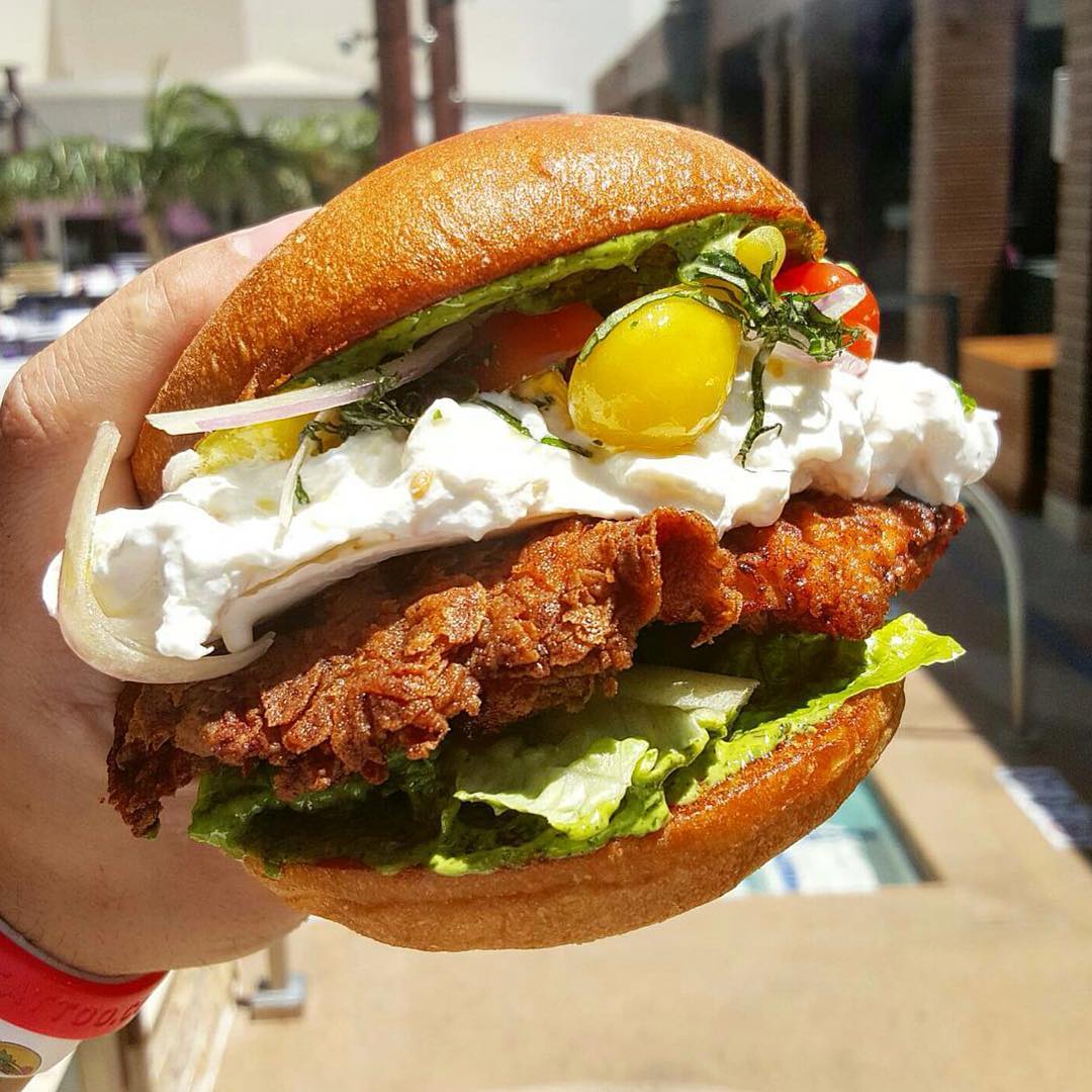 This Crispy chicken sandwich with buratta, heirloom tomatoes and pesto perfected by @chefmarcmarrone looks like HEAVEN on a bun!! 😜